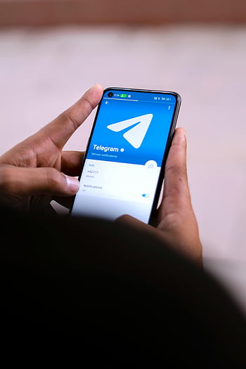 hands holding smartphone, close-up hands, Telegram app, smartphone screen, mobile app, service notifications, mobile device, digital communication, app interface, user interface, technology usage