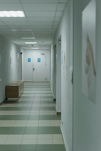Holul spitalului, iluminat moale, decor minimal, spital liniștit, parchet gresie, pereti albi, Facilitate medicală, mediu curat, Setarea asistenței medicale, design interior, atmosferă caldă