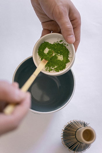 matcha di grado cerimoniale, tazza di ceramica, strumento di bambù, cerimonia tradizionale giapponese, tè matcha, mani ravvicinate, polvere di matcha, Preparazione del tè, cerimonia del tè, tè verde, frusta