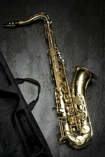 brass saxophone, gray table, black bag, golden saxophone, textured background, intricate design, musical instrument, saxophone design, dark background, saxophone photo, instrument photography