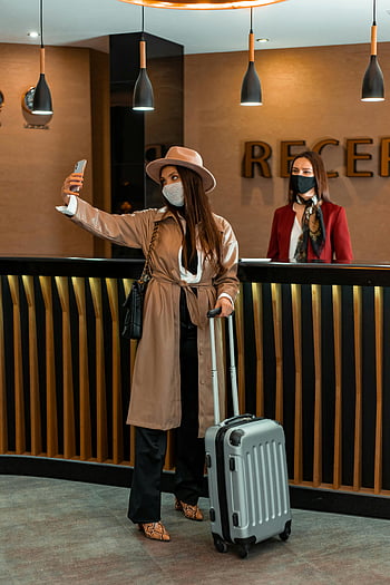 Selfieを取っている女性、 ホテルロビー、 レセプションエリア、 おしゃれな女性、 荷物、 受付、 旅行写真、 モダンなホテル、 ホテルでの自撮り、 旅行ファッション、 マスクを着ています
