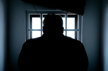 silhouette man, rear view, window bars, prison cell, backlit, dark silhouette, window, man in prison, rear perspective, confined space, solitude