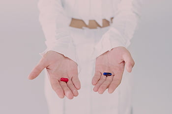 Femme tenant des pilules, pilules rouges et bleues, symbole de choix, prise de vue conceptuelle en studio, Clake-Up Hands, choix des médicaments, décision de pilule, concept de santé, choix pharmaceutique, image symbolique, photographie en studio