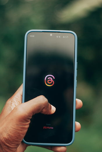 Tangan memegang smartphone, Aplikasi Meta Threads, foto close-up, latar belakang kabur, Tampilan smartphone, Logo Meta Threads, aplikasi seluler, perangkat digital, teknologi, aplikasi media sosial, antarmuka pengguna