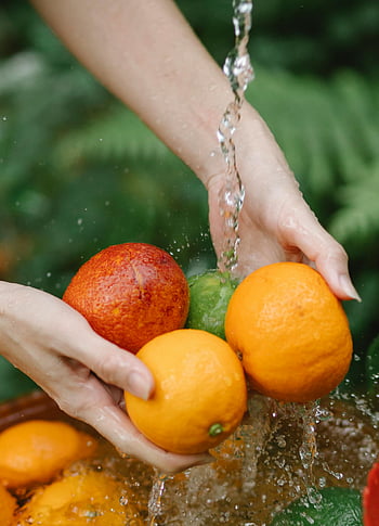 Vrouw wascitrus wassen, Verse rijpe sinaasappels, bloedsinaasappel, lopend water, gezonde levensstijl, Fruit wassen, citrus vruchten, verse sinaasappelen, Bloedsinaasappel wassen, gezond eten