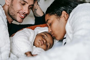 părinți veseli, dormind copilul, scenă confortabilă, familie iubitoare, părinți multietnic, copil în pat, Mama și tata, nou nascut, moment de familie, moment tandru, Părinți fericiți
