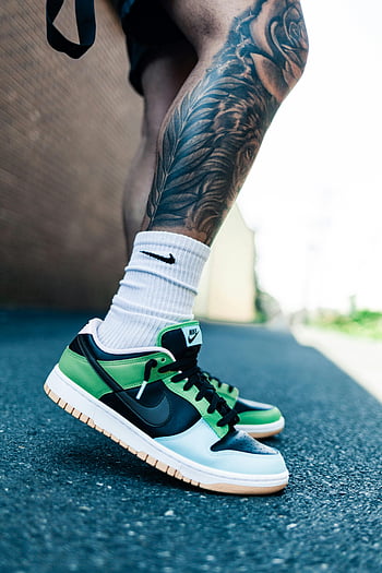 รองเท้าผ้าใบ nike, รอยสักที่ขา, รองเท้าผ้าใบสีเขียวและสีดำ, ภาพกลางแจ้ง, ภาพระยะใกล้, ถุงเท้า Nike, รูปแบบถนน, แฟชั่นในเมือง, รองเท้ากีฬา, ชุดลำลอง, การถ่ายภาพวิถีชีวิต
