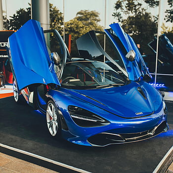 Blue McLaren 720S, luxury supercar, open doors, outdoor display, stunning blue, high-end vehicle, McLaren 720S, luxury style, supercar showcase, outdoor exhibition, blue sports car