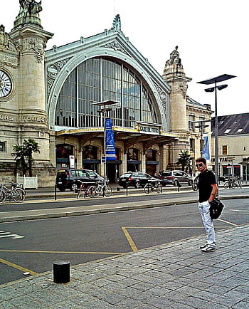 Tours, France, railway station, Gare de Tours, architecture, man walking, bicycles, cars, street, clock tower, palm trees