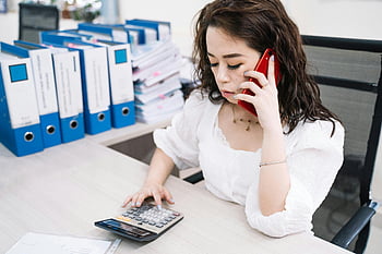 woman, talking on phone, using calculator, businesswoman, multitasking, office desk, cell phone, calculator, office work, professional, business