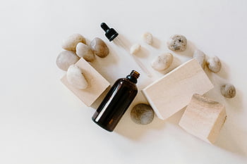fles met etherische olie, houten blokken, stenen, Wellness -thema's, plat leggen, bruine fles, natuurlijke elementen, aromatherapie, minimalistische compositie, Spa -producten, Ontspanningartikelen