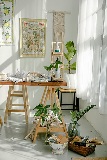 sunlit workshop, artisan studio, modern design, minimalist design, stack of clothes, table, plants, textiles, sunlight, spacious workshop, studio decor