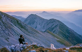 hiker, sunrise, Slovenian mountains, dog, serene, mountain view, outdoor adventure, nature photography, travel photography, mountain landscape, pet companion