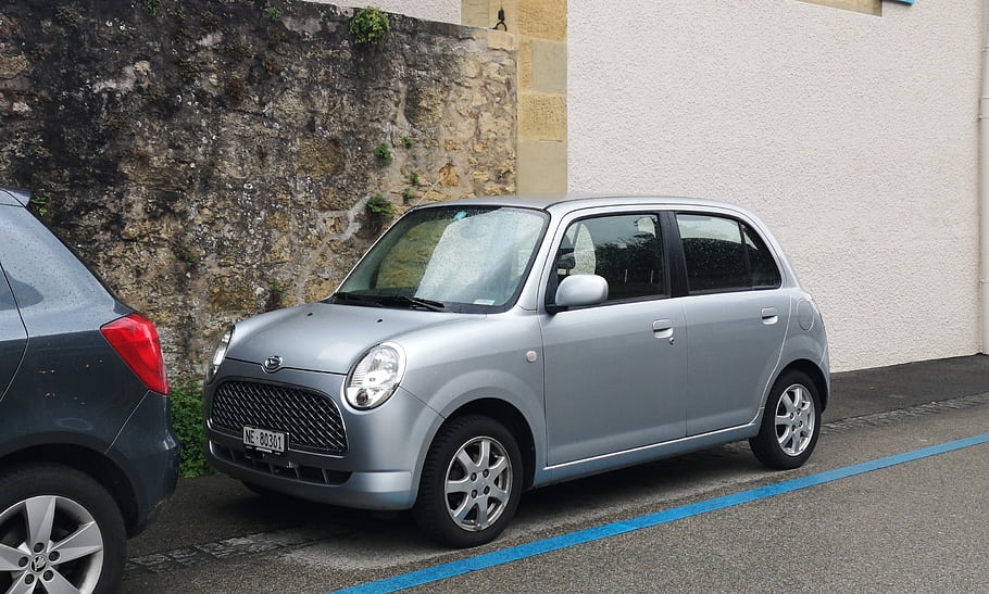 Daihatsu Trevis, silver car, compact car, parked car, urban setting, stone wall, blue line, street parking, small vehicle, front view, side view