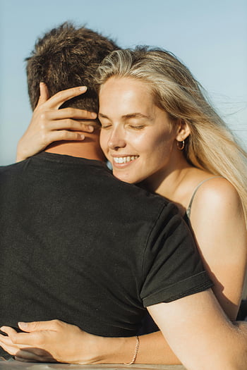 smiling woman, hugging man, joyful couple, embracing, clear sky, affection, love, outdoor, romantic, happiness, couple hug