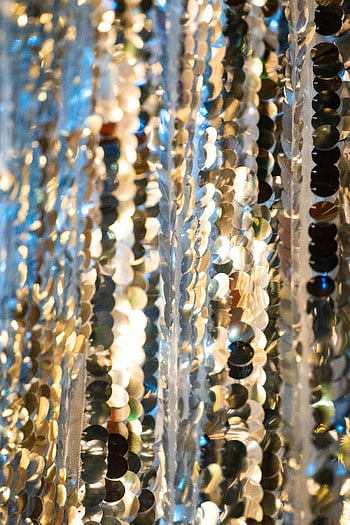 silver sequins, metallic sequins, vertical shot, sparkling effect, shiny sequins, light reflection, detailed photo, silver string, sequence, decorative sequins, festive background