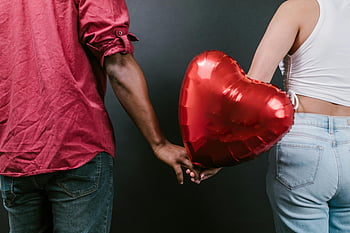 couple, holding hands, red heart-shaped balloon, love, togetherness, Valentine's Day, romantic, affection, relationship, heart symbol, balloon