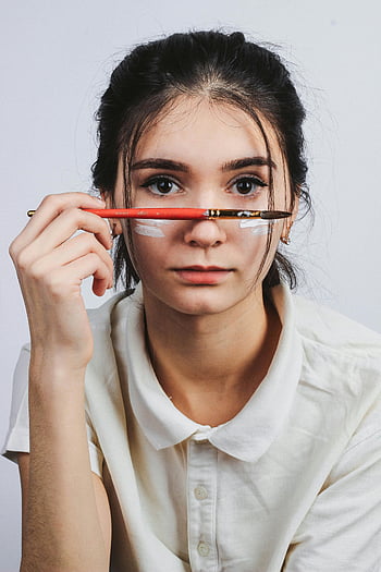 Frau, Pinsel, Ernsthafter Ausdruck, Innenporträt, junge Frau, weißes Hemd, gesichtsmalerei, künstlerisch, Innenfotografie, kreativ, Studioaufnahme
