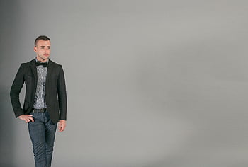 muž, černý sako, Šedá knoflíková košile, Černý motýlek, šedé kalhoty, drží boky, stojící, formální oblečení, studiový portrét, šedé pozadí, Profesionální oděv