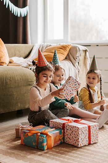 Les enfants qui ouvrent des cadeaux, fête d'anniversaire, Chapeaux de fête colorés, Cadeaux emballés, célébration intérieure, les enfants, atmosphère festive, Des enfants heureux, décorations de fête, Cadeau de déballage, réunion de famille