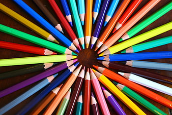 assorted-color pencils, circle formation, brown surface, vibrant spiral, colored pencils, rainbow spectrum, wooden desk, art supplies, creative arrangement, educational tools, colorful pencils