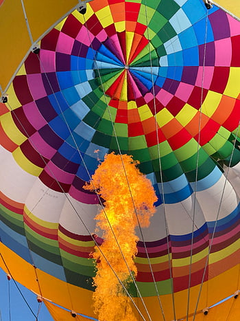 colorful hot air balloon, intense flame, blue sky, adventure, vibrant colors, aerial view, hot air ballooning, sky adventure, colorful balloon, flame, sky view