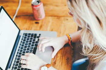 kvinne som jobber eksternt, laptop, tre pult, drikke boks, typing, eksternt arbeid, Svart og grå bærbar PC, hjemmekontor, jobbe hjemmefra, Uformell arbeidsområde, blondt hår