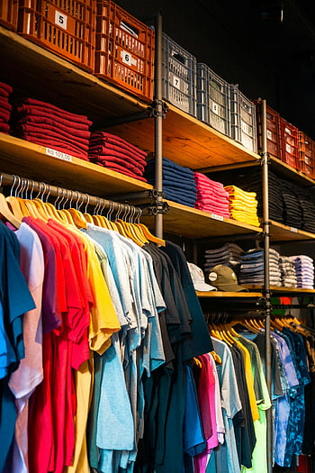 clothing boutique, vibrant t-shirts, neatly displayed, organized boutique, colorful shirts, retail display, fashion store, apparel store, clothing store, t-shirt collection, boutique setting
