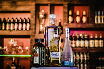 spritflaskor, barhylla, elegant display, diverse sprit, suddig bakgrund, alkoholflaskor, bar inställning, dricksval, dryckesvisning, bardisk, flaska arrangemang