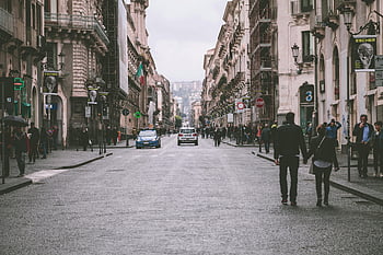 couple holding hands, European street, bustling street scene, architecture, street between buildings, urban scene, city life, romantic couple, street photography, European city, couple walking