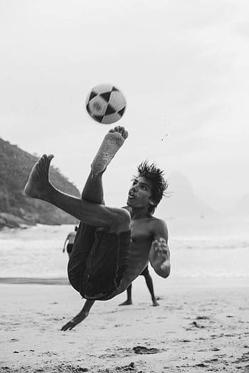 grijswaardenfotografie, man te voetballen, fietsschop, Het strand van Rio, zwart en wit, voetbal, strandvoetbal, actie foto, sportfotografie, buitensport, atletische man