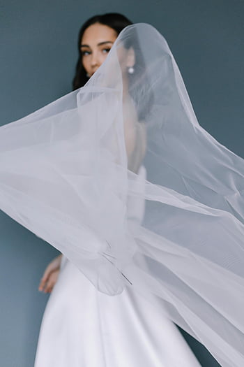 studiový portrét, nevěsta, tekoucí závoj, elegance, tradice, bílé šaty, svatební oděv, svatební móda, studiové fotografie, svatební portrét, milost