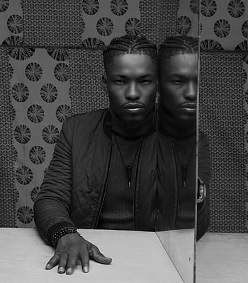 man sitting on table, mirror reflection, monochrome portrait, serious man, black and white, reflection in mirror, man with reflection, table with mirror, man and mirror, black and white photography, serious expression