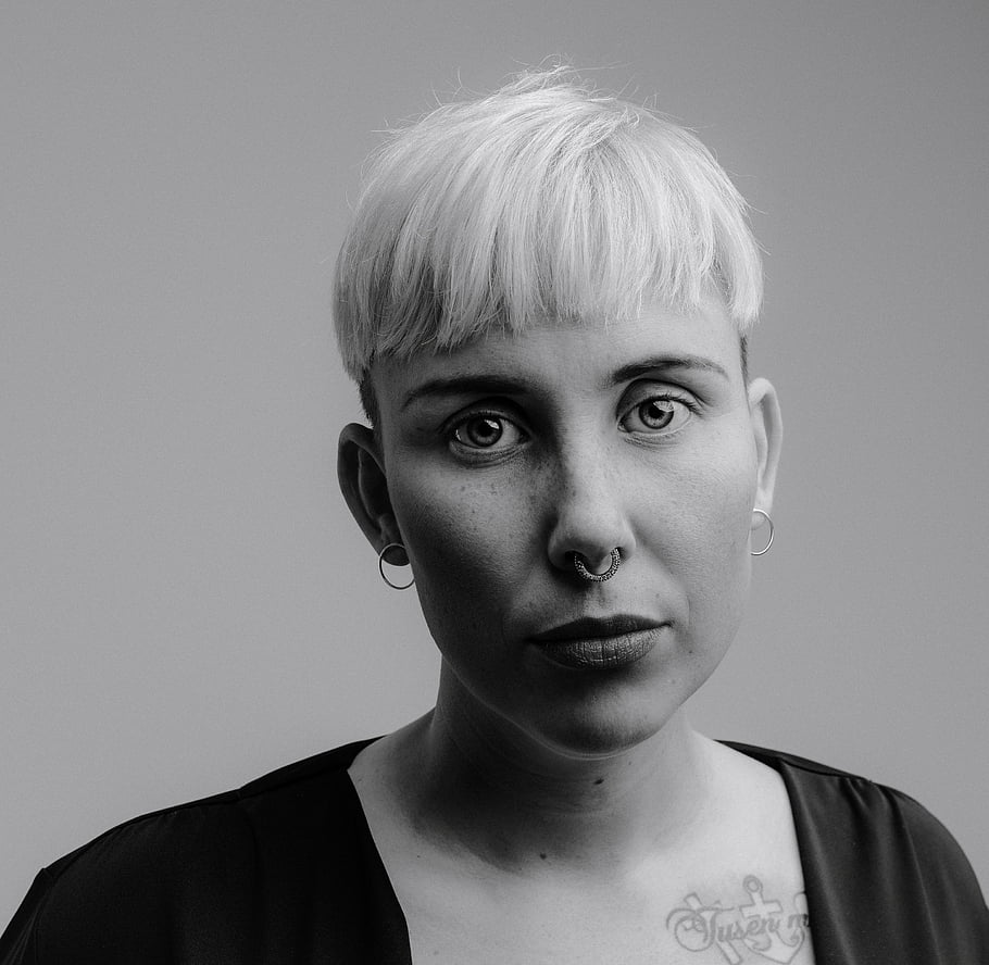 s nosním kroužkem, Monochromatický portrét, krátké vlasy, nos piercing, Černý a bílý, portrétní fotografie, piercing v obličeji, moderní styl, minimalistické pozadí, ženský portrét, Monochromatický obrázek