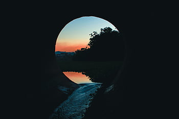 Golden Hour, sunset, tunnel view, calm water, reflections, tranquil scene, evening light, natural beauty, serene landscape, outdoor photography, peaceful moment