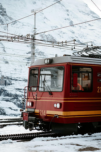 red train, snowy mountains, Swiss Alps, winter landscapes, transportation, train station, snowy scenery, Swiss train, mountain train, winter travel, red locomotive