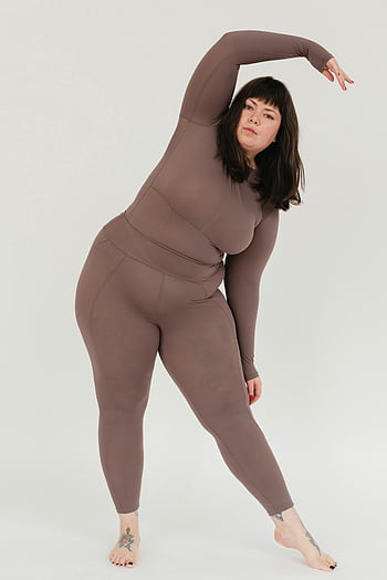 plus-size woman, stretching, body positivity, wellness, yoga, studio, confident, white background, tattoo, barefoot, fitness