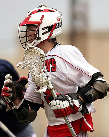giocatore di lacrosse, uniforme bianca e rossa, gioco concentrato, casco, bastone di lacrosse, azione sportiva, Atleta maschio, Uniforme di squadra, sport competitivo, giochi all'aperto, equipaggiamento protettivo
