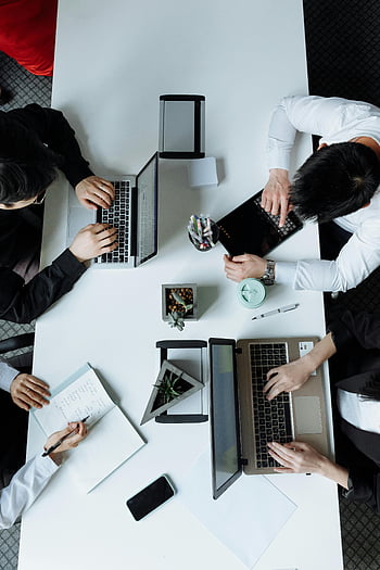 Überkopfschuss, Gruppentreffen, vielfältiges Team, modernes Büro, Laptops, Zusammenarbeit, Arbeitsumgebung, professionelle Einstellung, Zusammenspiel, Büroarbeitsplatz, Geschäftstreffen