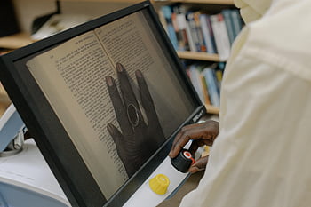 lupa digital, acessibilidade de texto, ajuda de leitura, leitura de livro, Tecnologia assistiva, deficiência visual, texto aprimorado, computador tablet, pessoa lendo, dispositivo de acessibilidade, ferramenta de ampliação