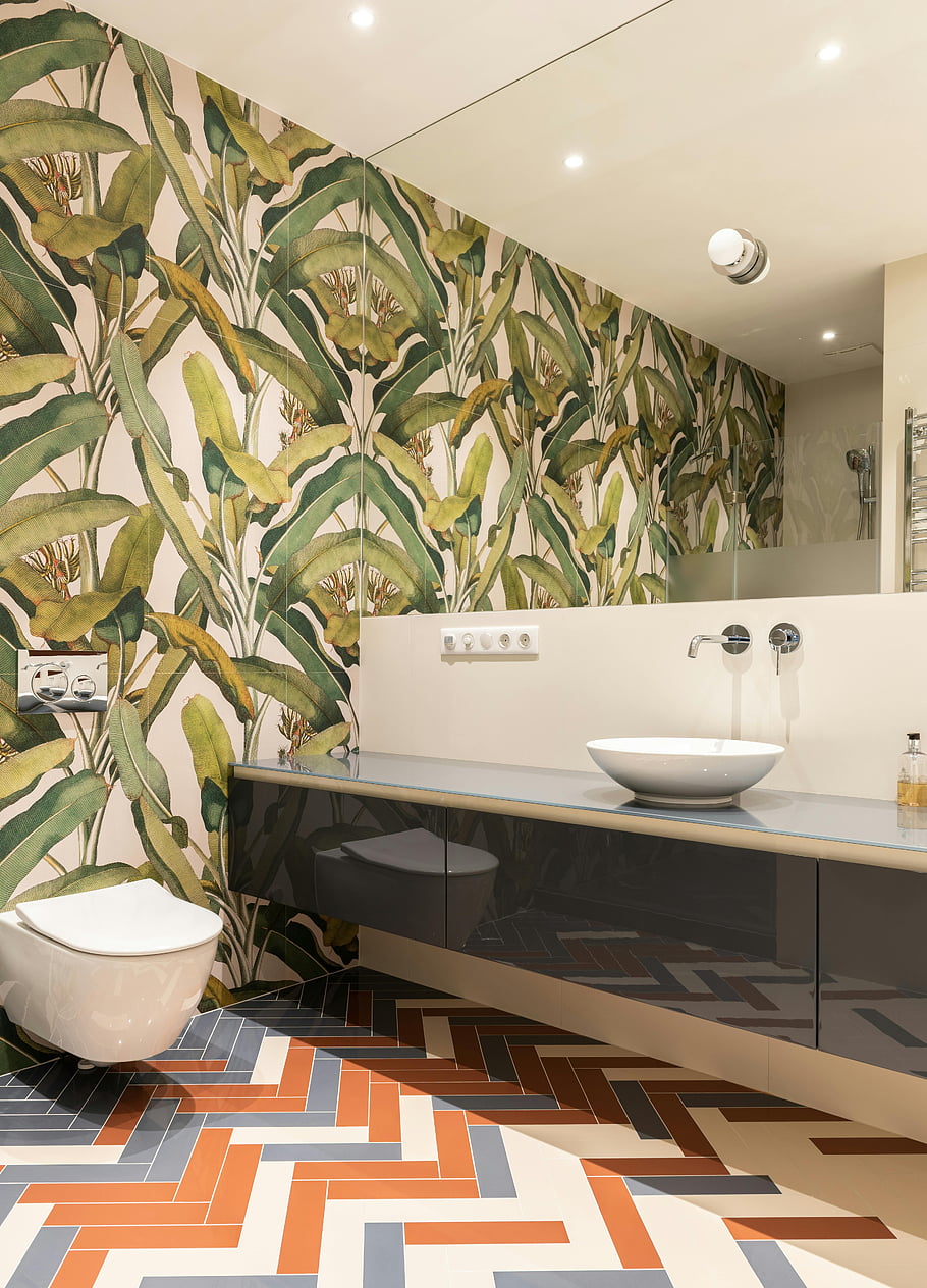 athroom interior, sink on cabinet, toilet, mirror, bold botanical wallpaper, contemporary design, stylish bathroom, herringbone tile floor, modern bathroom, interior design, home decor