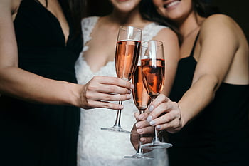 wedding celebration, champagne glasses, rose wine, women toasting, close-up photo, wedding toast, festive moment, elegant celebration, bridal party, celebratory drinks, champagne clinking