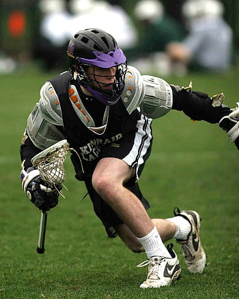 giocatore di lacrosse, maglia sportiva nera, Azione media, gioco di sport, scatto dinamico, bastone di lacrosse, equipaggiamento protettivo, sport all'aperto, azione atletica, sport da campo, intensità della concorrenza