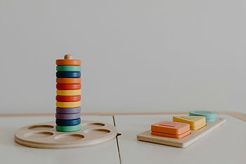 färgglada träleksaker, utbildningsleksaker, hållbart lärande, minimalistisk närbild, vit vägg, trä block, färgglada block, Lärande leksaker, miljövänliga leksaker, barnleksaker, pedagogiska spel