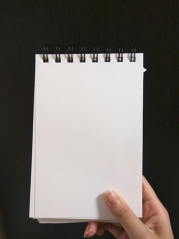 Ruční držení notebooku, prázdný spirálový notebook, detailní pohled, Připraveno k psaní, kreslení, prázdný zápisník, bílé stránky, černé pozadí, osoba drží, prázdné stránky, Spirálová vazba