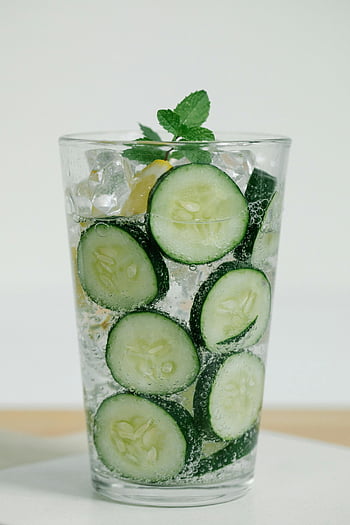 cucumber water, drinking glass, cucumber slices, mint infused, sparkling water, lemon slices, refreshing drink, close-up, ice cubes, mint leaves, cucumber mint water