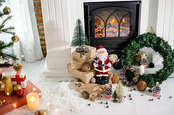 Christmas decorations, toys, fireplace, Santa figurine, cozy indoor setting, warm Christmas setup, gifts, wreath, pinecones, candles, Christmas tree