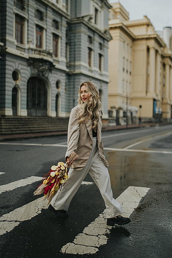 kvinde krydser vejen, Levende efterårsbuket, elegant kvinde, bymæssige omgivelser, gadekrydsning, efterår blomster, bybilledet, mode, gadestil, buketter, urban mode