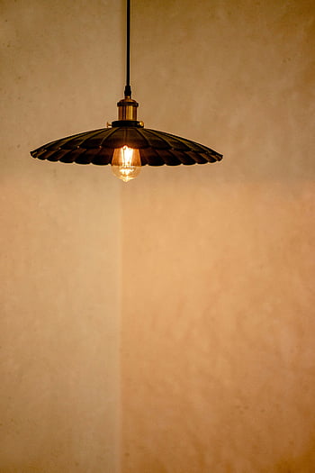 vintage pendant lamp, glowing light bulb, minimalist beige wall, interior decor, classic lamp, warm lighting, ceiling lamp, hanging lamp, retro lighting, home decor, ambient light