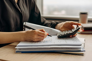 Person, Langarm-Shirt, Halterechner, Nahansicht, Finanzdokumente, Büro, Schreibtisch, Papierkram, Stift, Arbeiten, Berechnungen